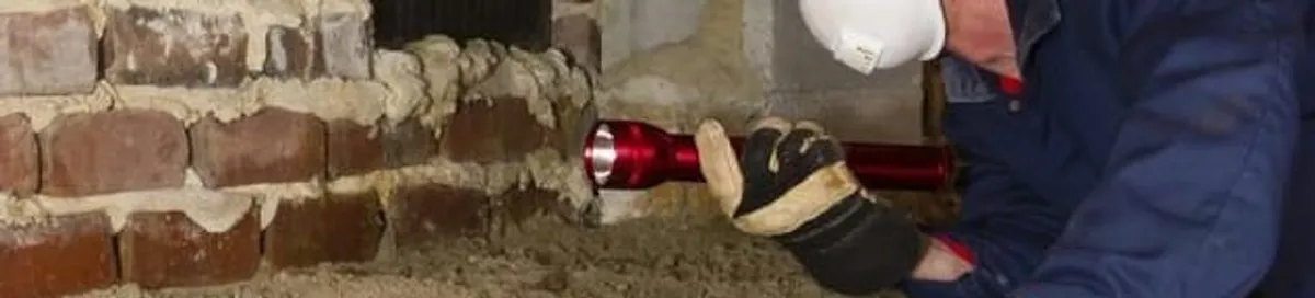 Pest control technician inspecting a crawl space for ant activity and entry points in Cleveland, OH